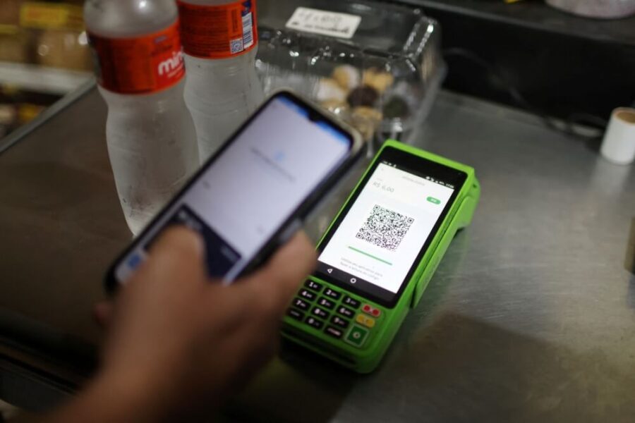 maquininha de pagamento de cartão verde e um celular