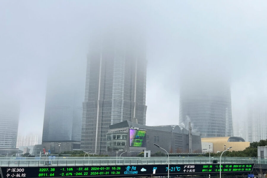nuvens tampando o topo de um prédio comercial com números do setor imobiliário