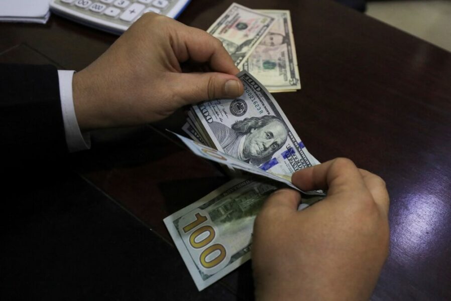 imagem de mãos segurando notas de dólar