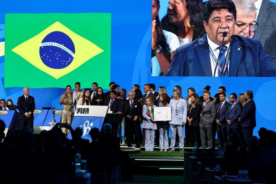 pessoas em cima de um palco com bandeira do brasil no fundo