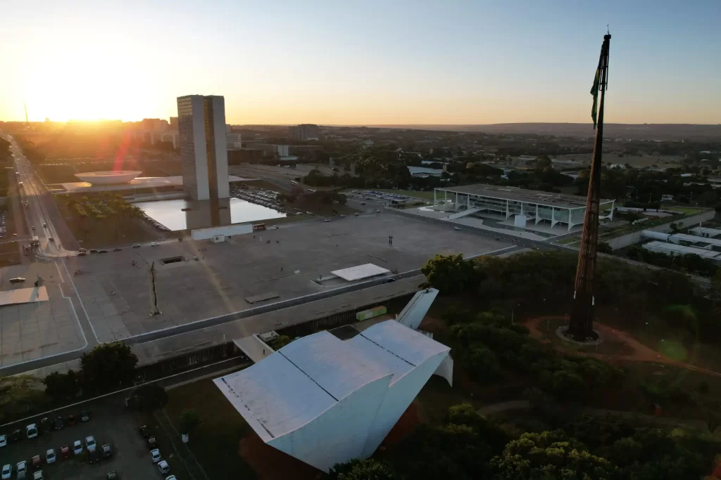 Vista panorâmica de Brasília ao pôr do sol, destacando a arquitetura moderna e os importantes edifícios públicos da capital brasileira.