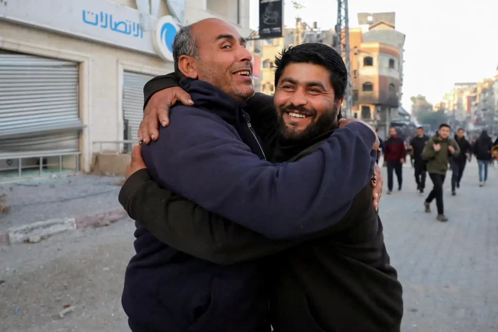 Momentos de alegria e amizade são retratados nesta imagem, onde dois homens se abraçam em um ambiente urbano, transmitindo uma forte sensação de conexão e felicidade.