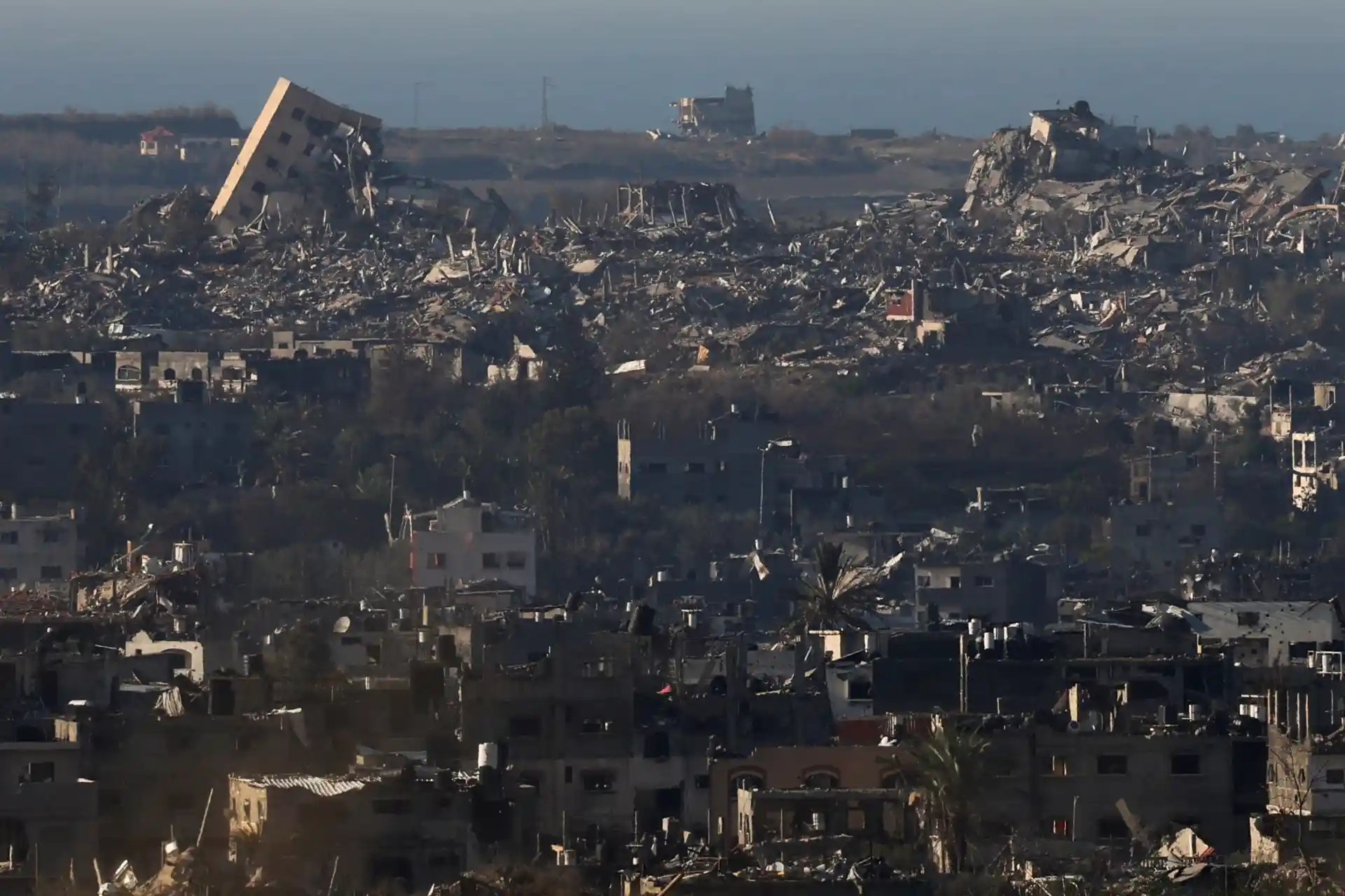 Imagem de uma área devastada, mostrando prédios destruídos e escombros, refletindo os impactos de conflitos e desastres naturais.