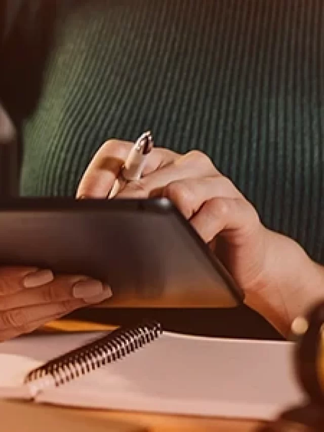 Story Mão de mulher segurando tablet próximo a balança de justiça e martelo em mesa.