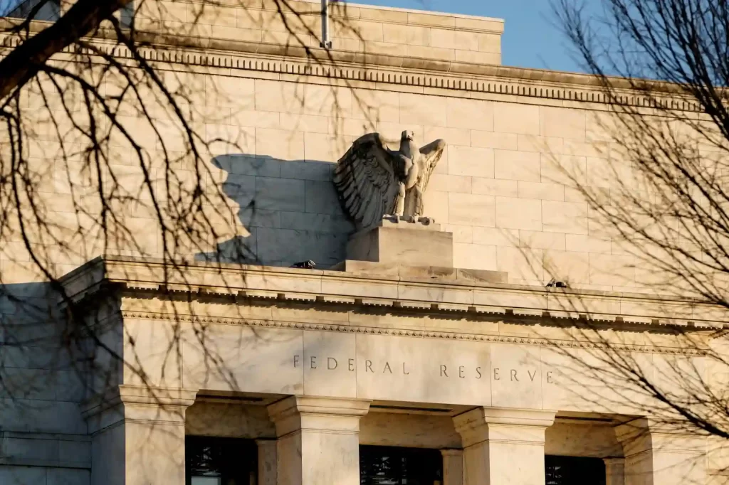 Imagem do edifício do Federal Reserve, destacando a escultura da águia e a inscrição Federal Reserve na fachada em estilo neoclássico.