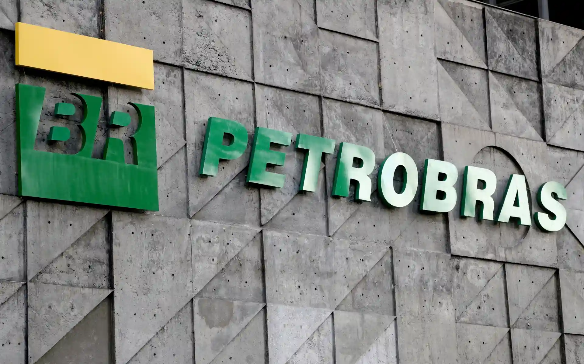 Logotipo da Petrobras na parede de um edifício, destacando a marca e os elementos visuais que representam a empresa de petróleo.