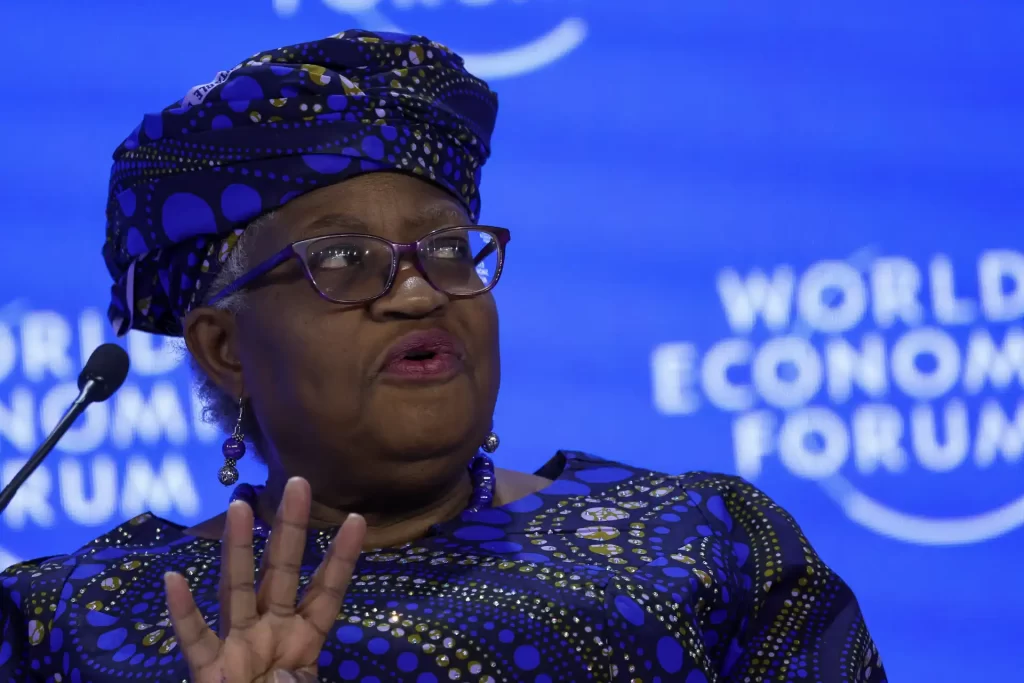 Ngozi Okonjo-Iweala durante uma discussão sobre economia global no Fórum Econômico Mundial, com um vestido colorido e turbante.