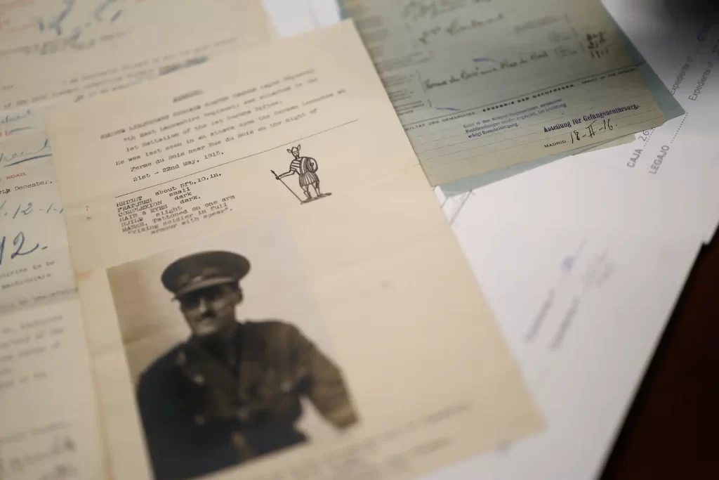 Imagem contendo documentos históricos, incluindo uma foto de um oficial militar e cartas antigas. Os documentos estão sobre uma mesa, destacando a antiguidade dos itens.