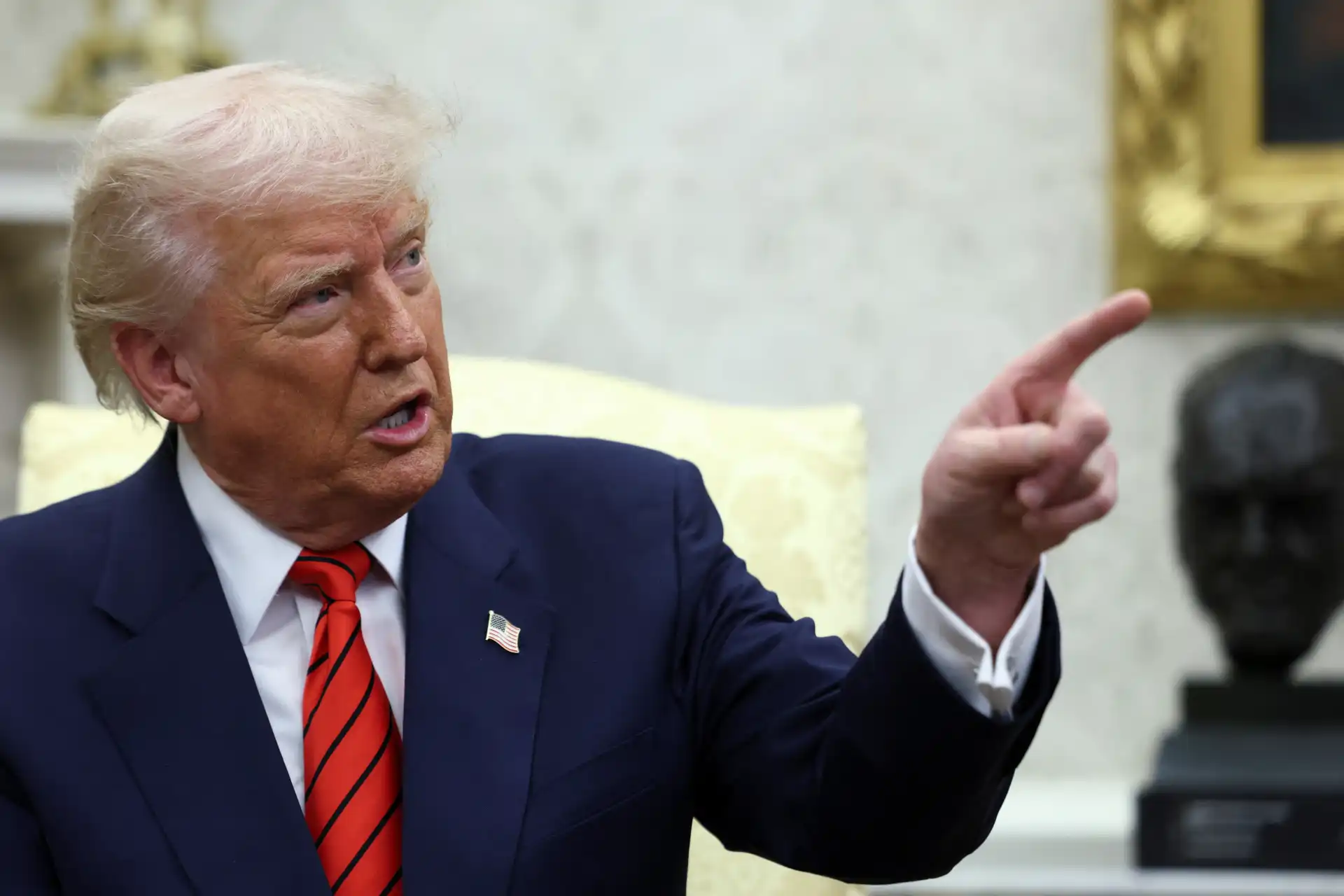 Donald Trump gesticulando durante uma conversa na Casa Branca, destacando momentos importantes da política americana.
