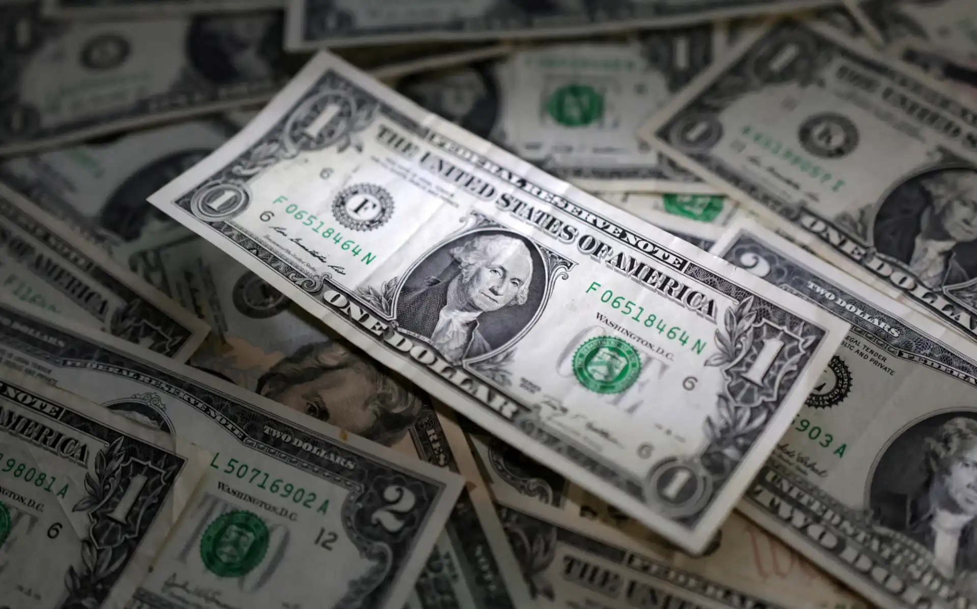Notas de dólar americano empilhadas, destacando a variedade de denominações e o icônico design que simboliza a economia dos Estados Unidos.