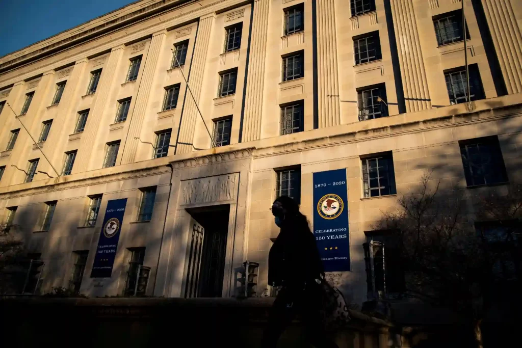 Imagem do prédio do Departamento de Justiça dos Estados Unidos, em comemoração aos 160 anos da instituição, com bandeiras e arquitetura imponente.