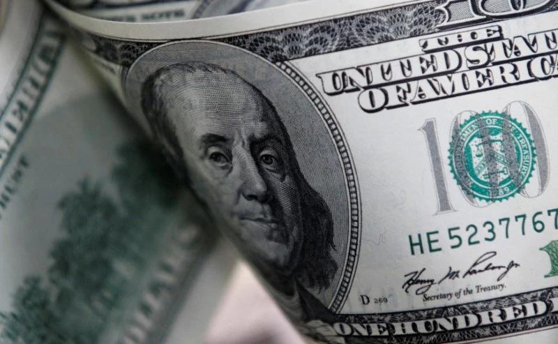 Cédulas de dinheiro dos Estados Unidos destacando a nota de 100 dólares com o retrato de Benjamin Franklin, simbolizando riqueza e economia.