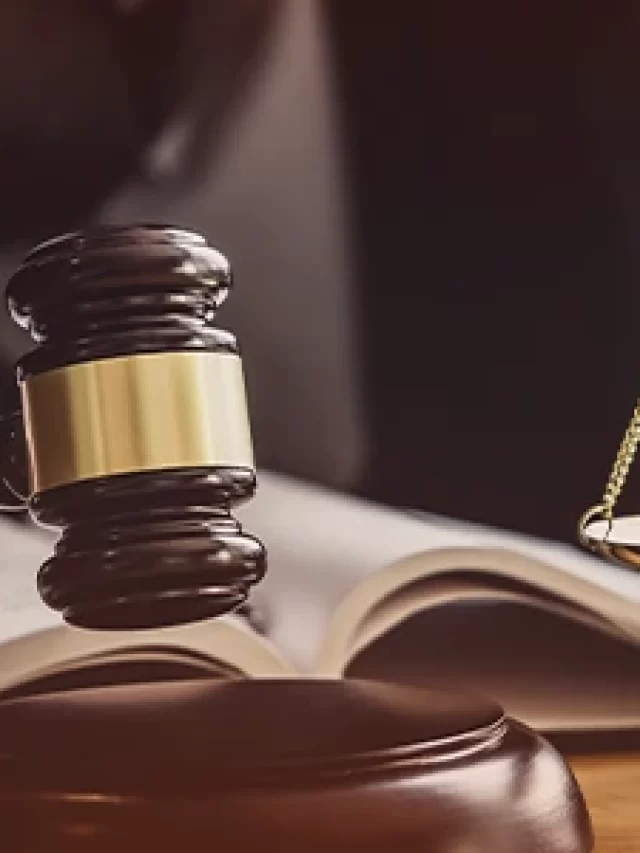 Story Imagem de um juiz segurando um martelo de jurisdição, com balança de justiça ao lado, em um ambiente que remete ao âmbito jurídico, representando o sistema legal.