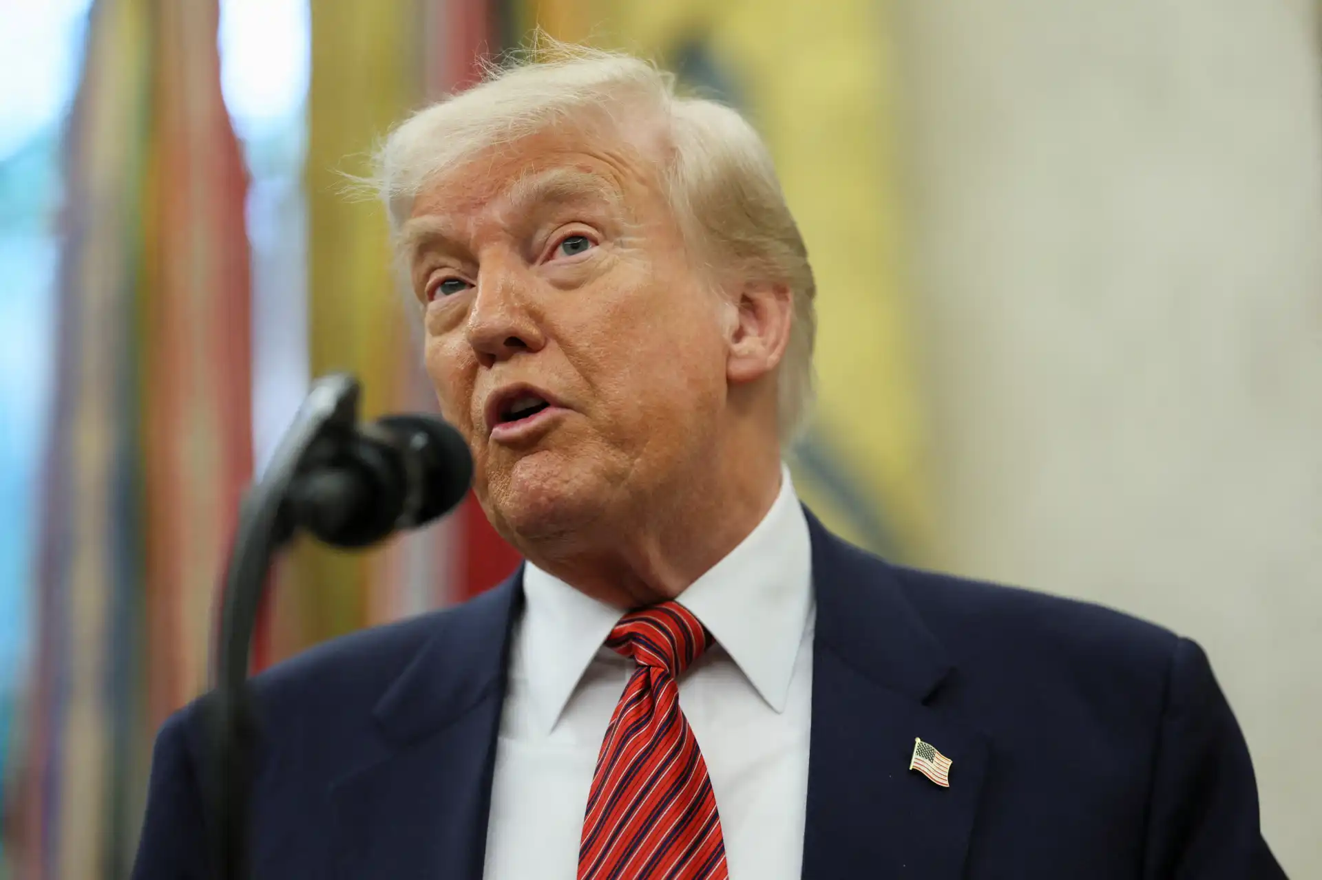 Donald Trump durante um discurso, evidenciando seu estilo de comunicação e imagem pública. O ex-presidente discute temas importantes em um ambiente formal.