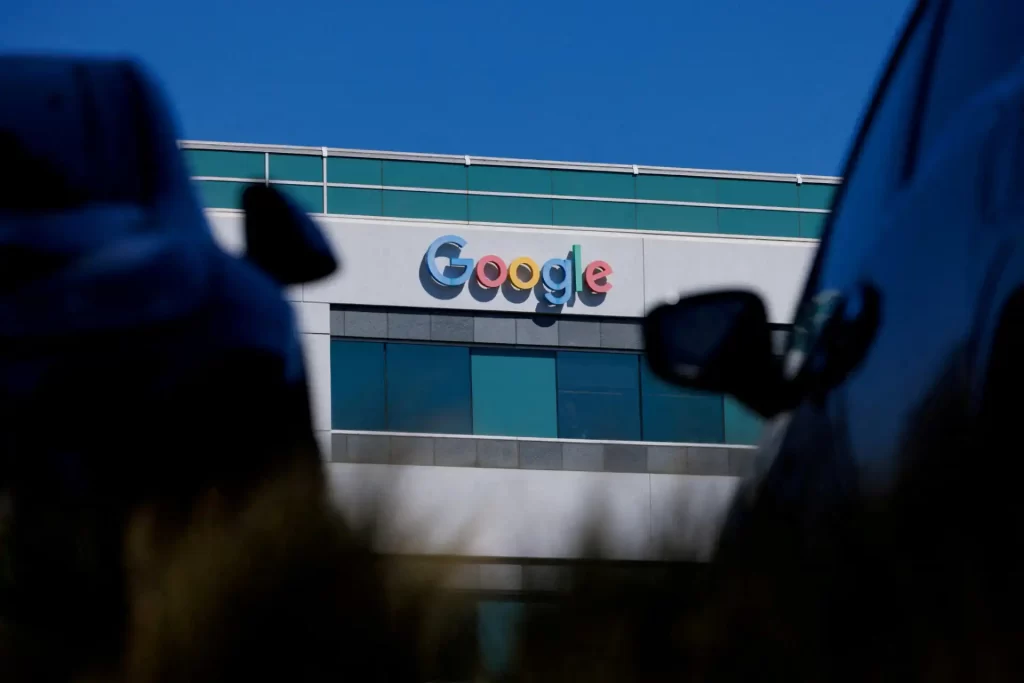 Edifício da Google com o famoso logotipo no centro da imagem, destacando as cores e a arquitetura moderna, sob um céu azul claro.
