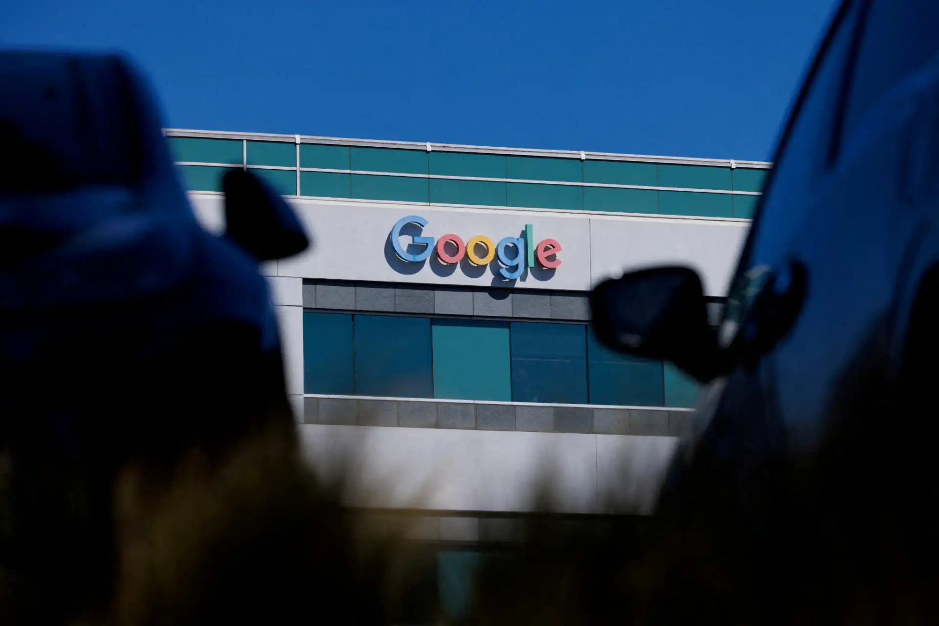 Edifício da Google com o famoso logotipo no centro da imagem, destacando as cores e a arquitetura moderna, sob um céu azul claro.
