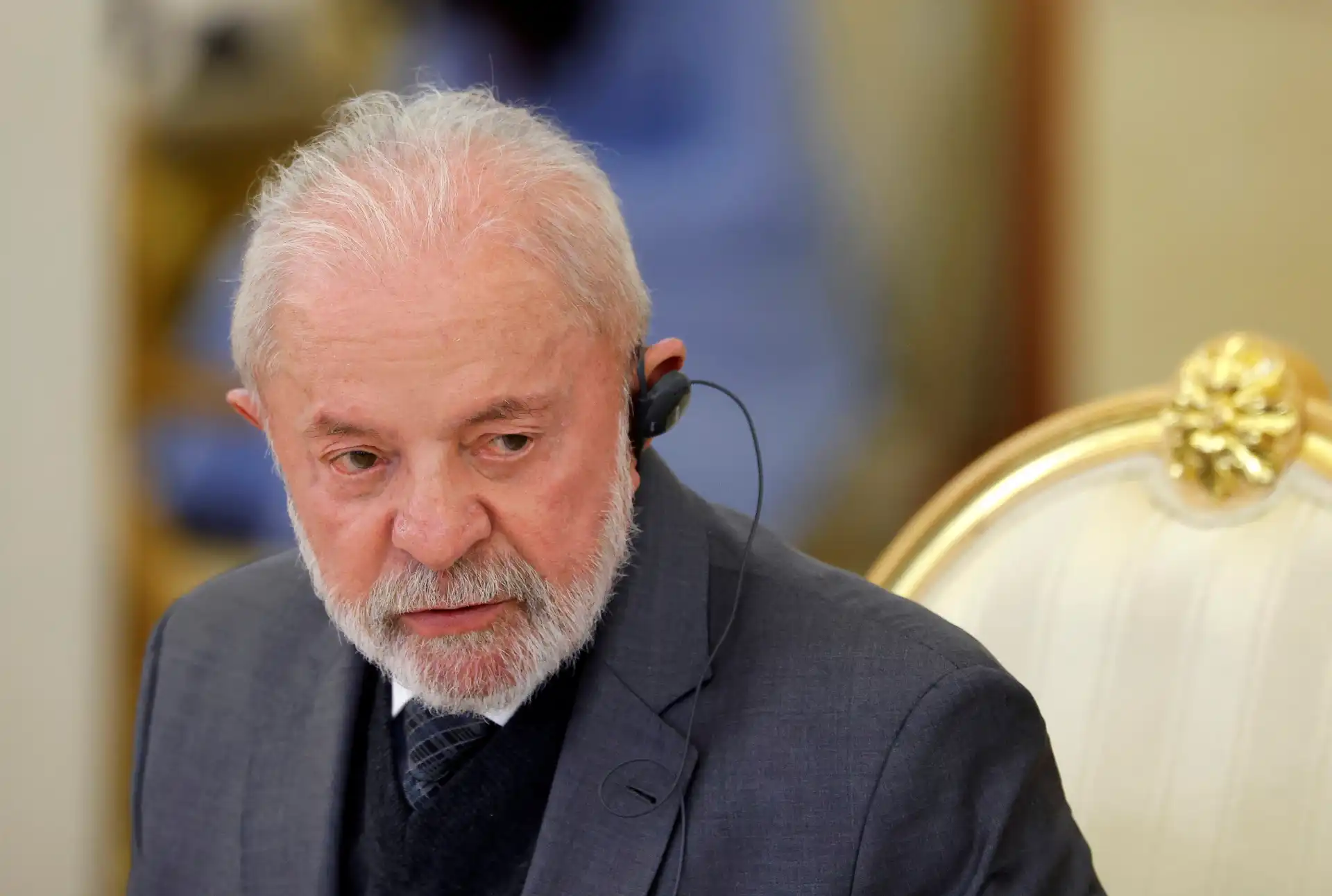 Lula da Silva em uma conferência, usando fones de ouvido e com expressão pensativa, refletindo sobre temas importantes para o Brasil.