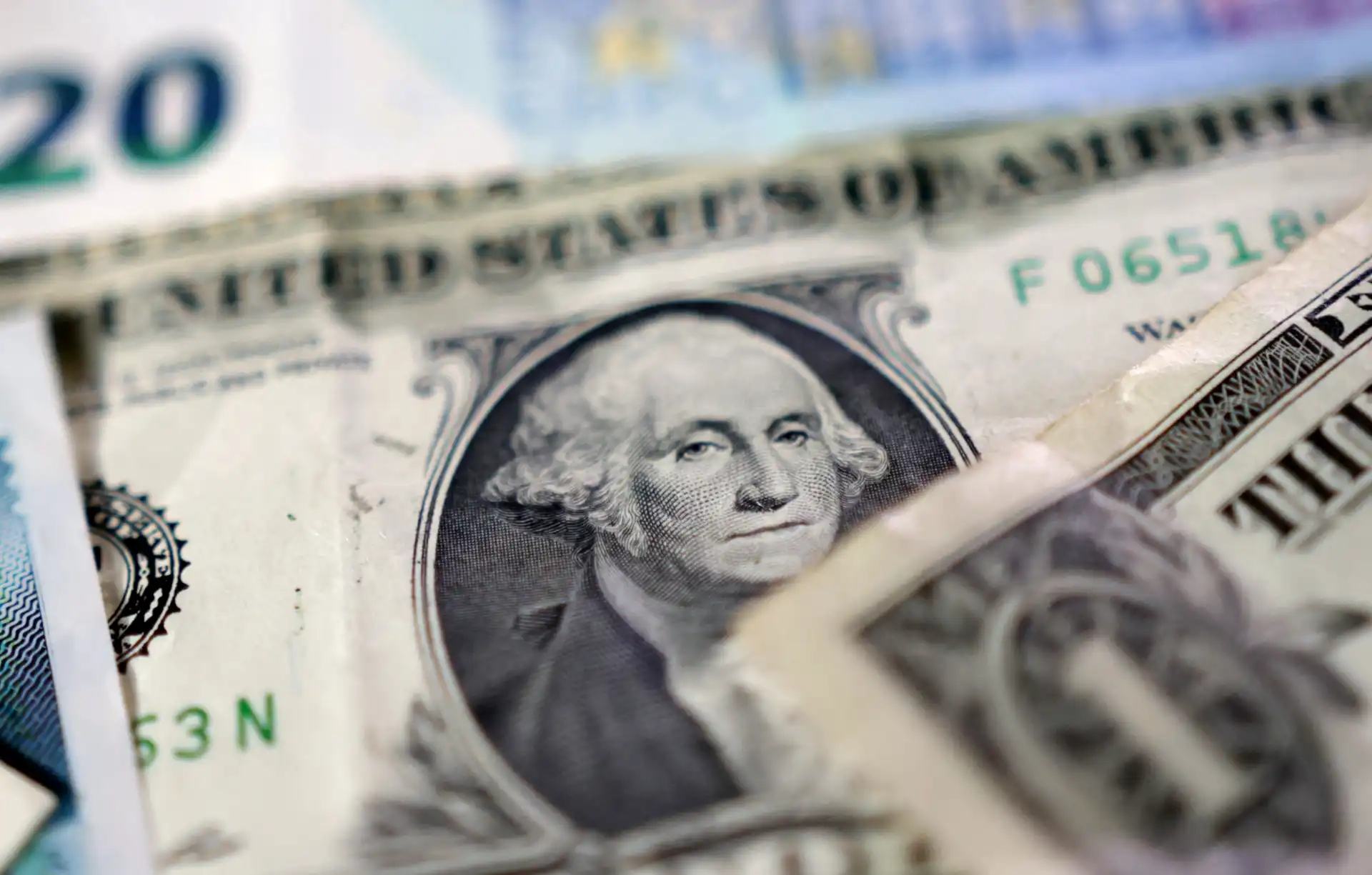 Imagem em close de notas de dinheiro dos Estados Unidos, destacando detalhes como o rosto de George Washington em uma nota de um dólar. Ideal para assuntos financeiros.