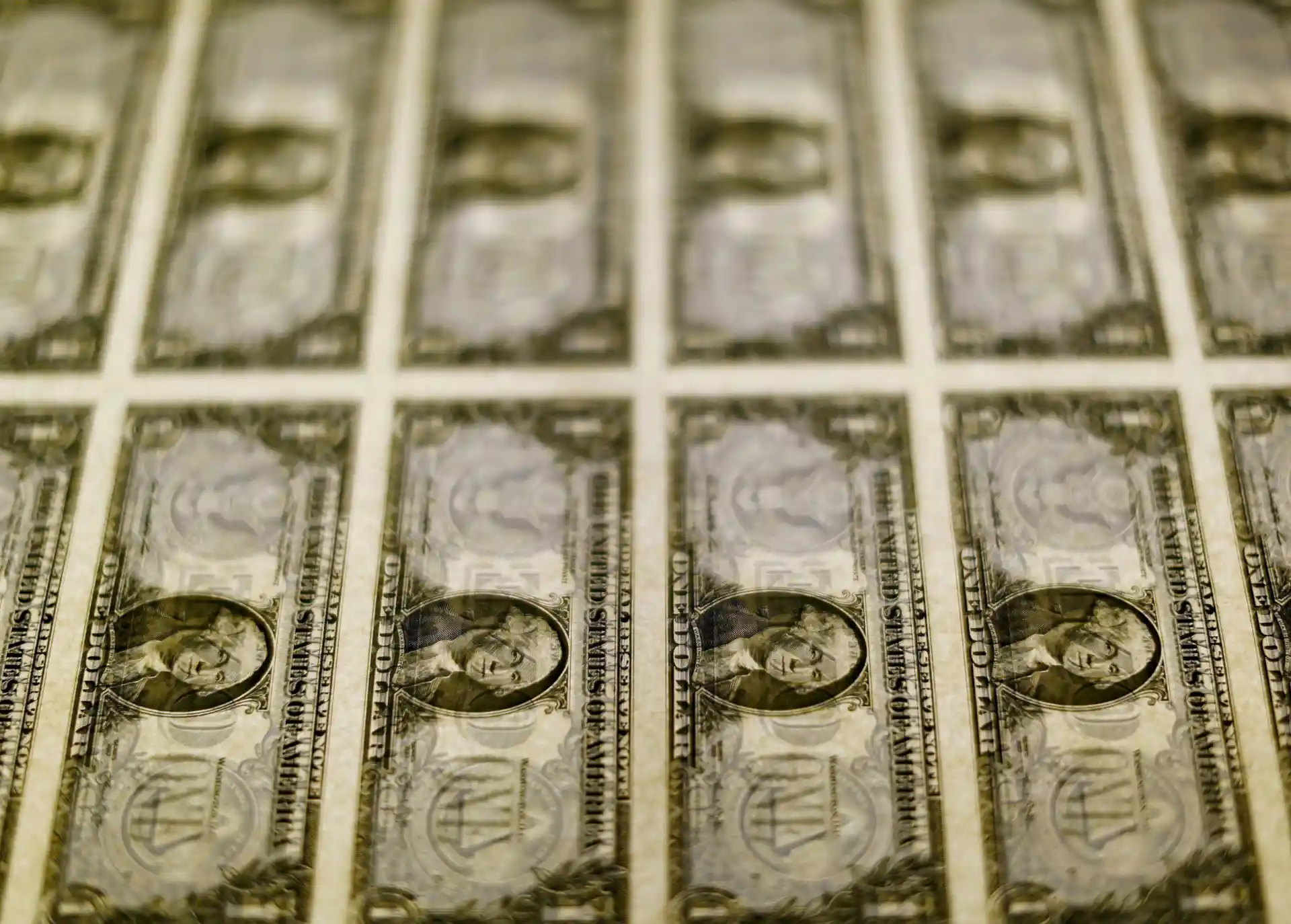 Imagem de notas de um dólar alinhadas em padrão, evidenciando seu design e detalhes, ideal para exemplificar dinheiro e economia.