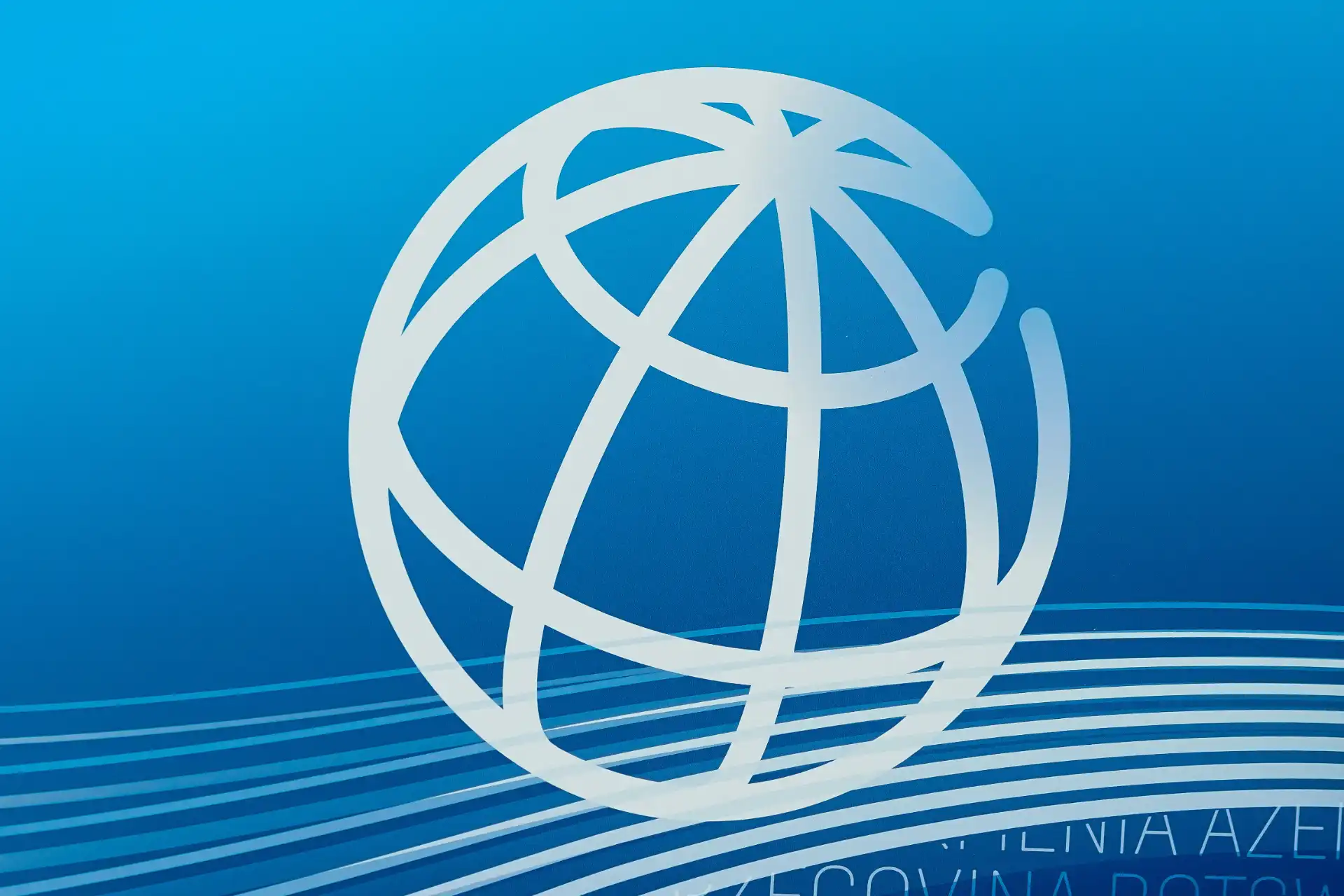 Imagem de um globo terrestre estilizado em branco sobre fundo azul, representando o conceito de globalização e conectividade mundial.