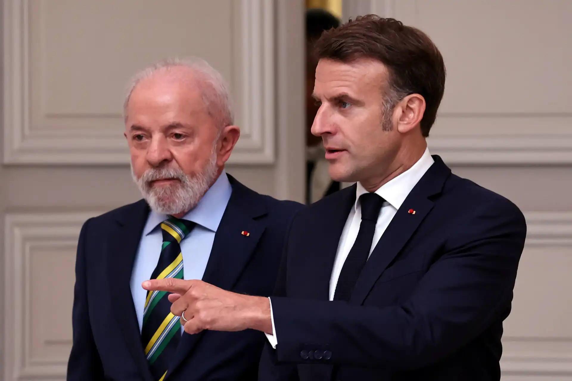 Imagem de dois homens de terno em uma conversa séria, um deles apontando com o dedo, em ambiente formal. Fotografia que transmite discussão ou debate político.