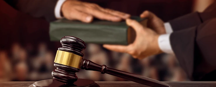 Imagem de uma audiência no tribunal do júri com o juiz usando um martelo de julgamento, simbolizando o poder da justiça e o processo judicial.