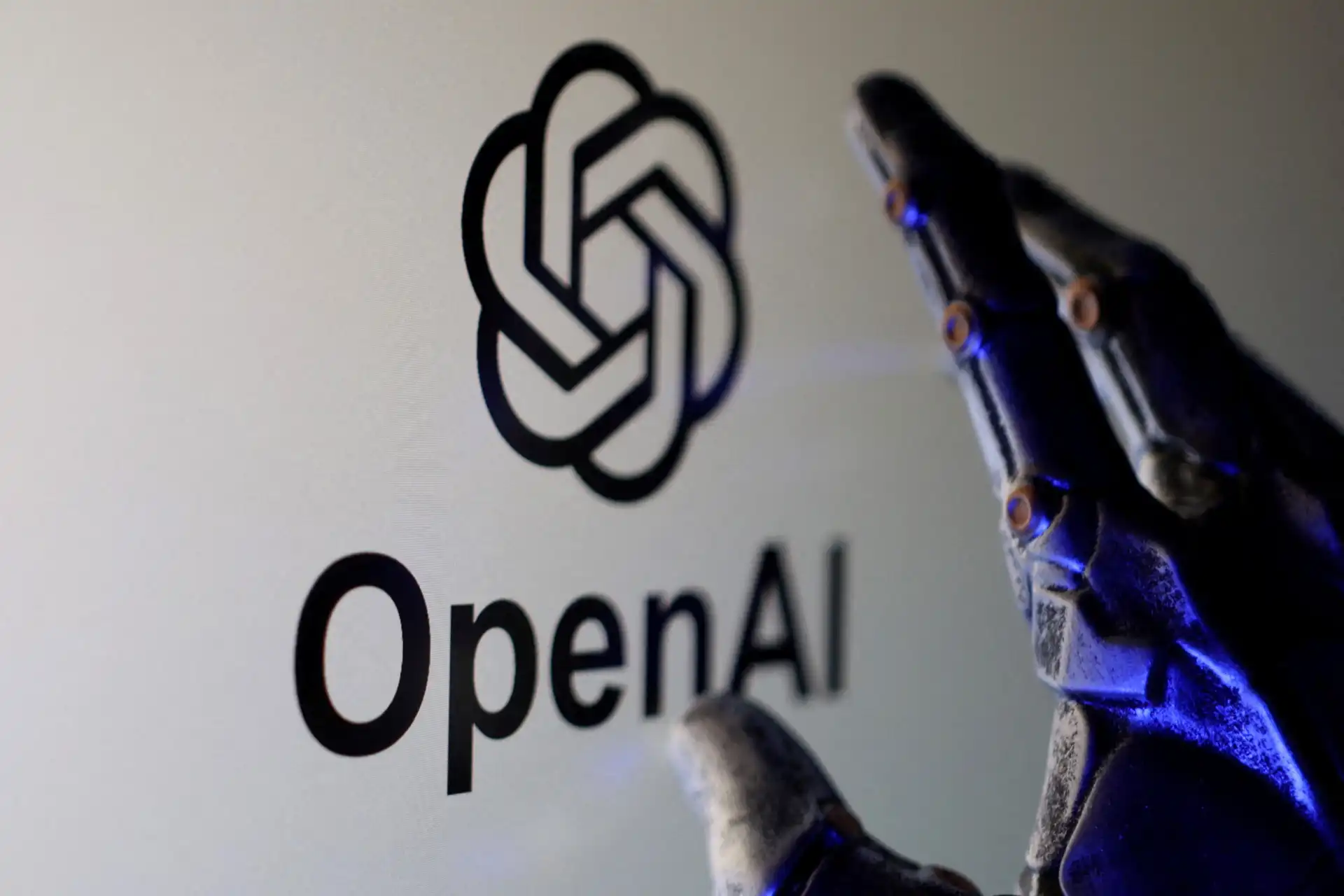 Imagem de uma mão robótica segurando um dispositivo próximo ao logotipo da OpenAI, destacando a tecnologia de inteligência artificial avançada. A imagem transmite inovação e o uso de IA no desenvolvimento de soluções inteligentes.