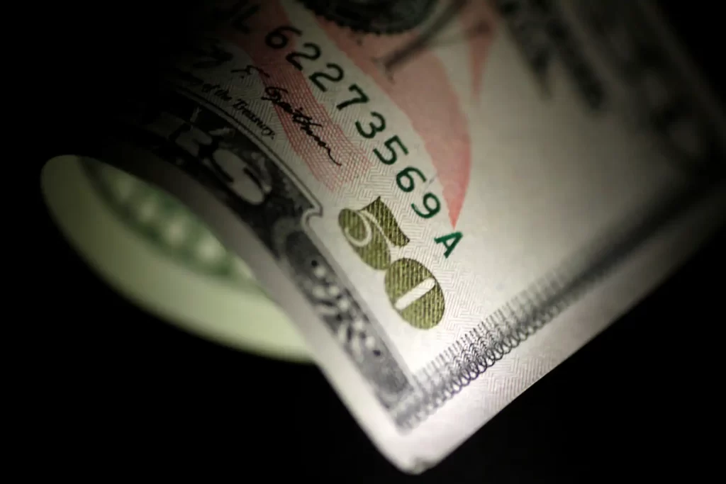 Imagem de uma nota de dólar de cinquenta dólares, em foco e com destaque para detalhes e segurança da cédula.