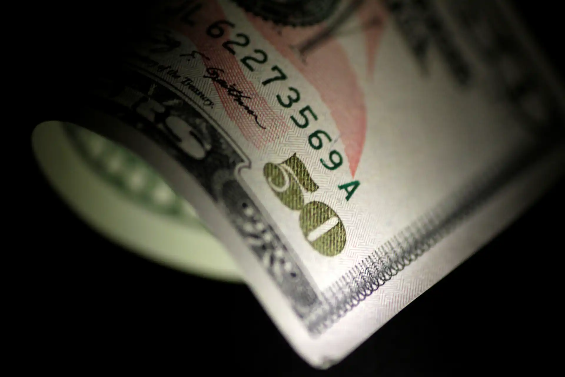 Imagem de uma nota de dólar de cinquenta dólares, em foco e com destaque para detalhes e segurança da cédula.