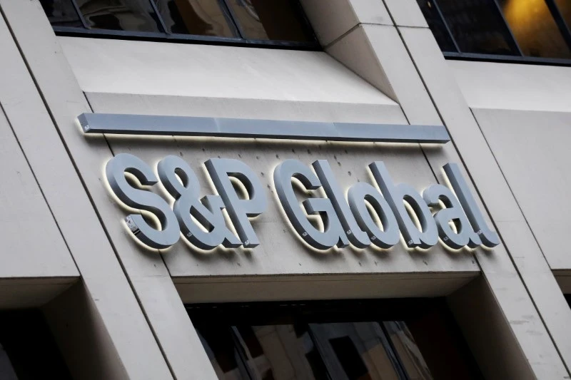Imagem do edifício da S&P Global com foco na fachada e no logo em destaque na cidade.