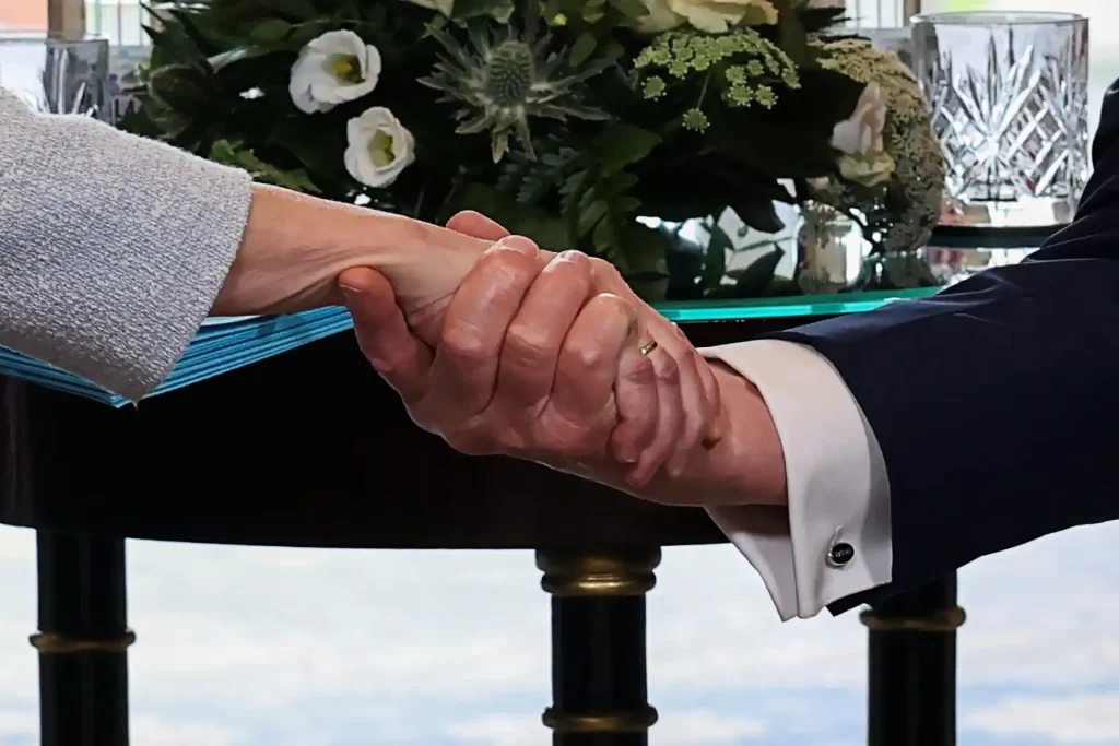 Imagem de um aperto de mãos entre duas pessoas de negócios em um ambiente formal, simbolizando parceria, acordo ou colaboração empresarial.