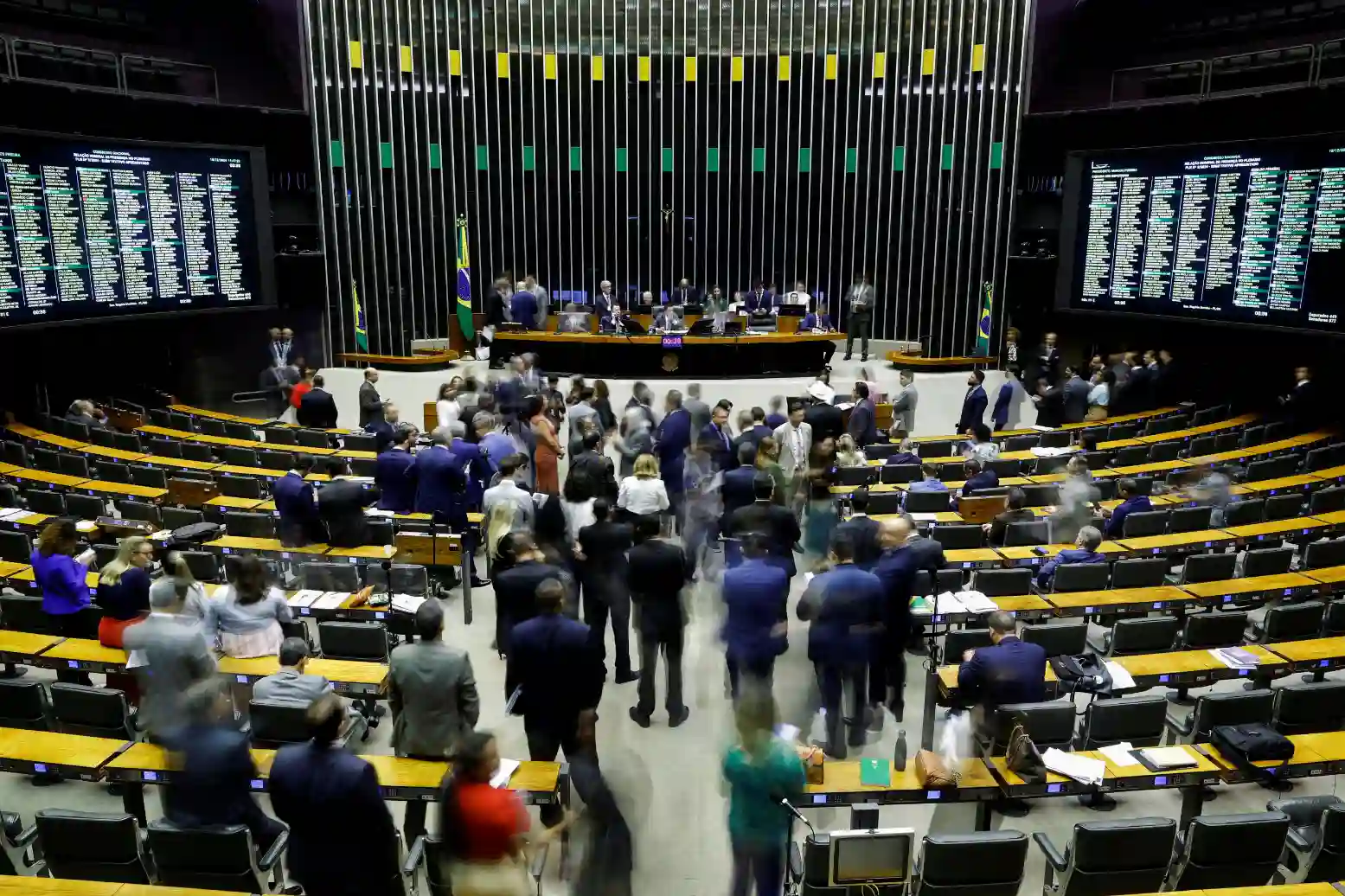 Sessão da Assembleia Legislativa do Brasil com deputados e funcionários no plenário, ambiente de trabalho político.