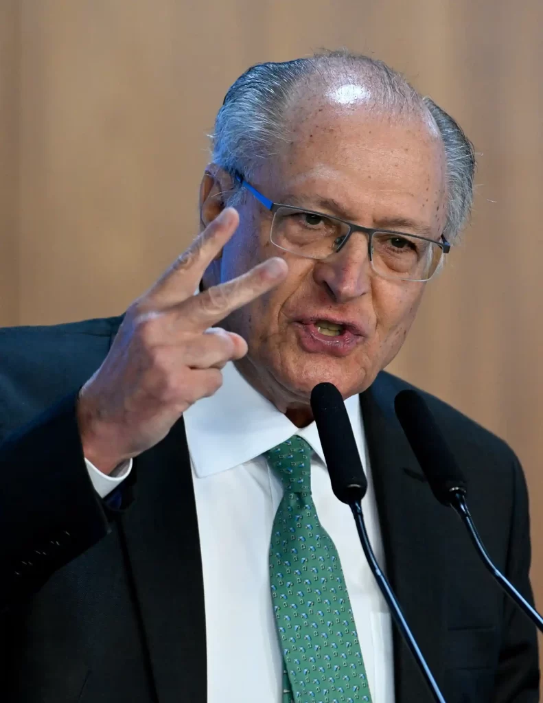 alckmin durante discurso, fazendo gesto com a mão enquanto fala em púlpito com microfones, apresentando expressão séria.