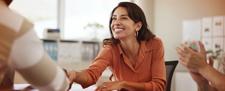 Mulher sorridente em ambiente de escritório, demonstrando felicidade e entusiasmo, ideal para conteúdos sobre networking, empatia ou clima organizacional. paulo scott