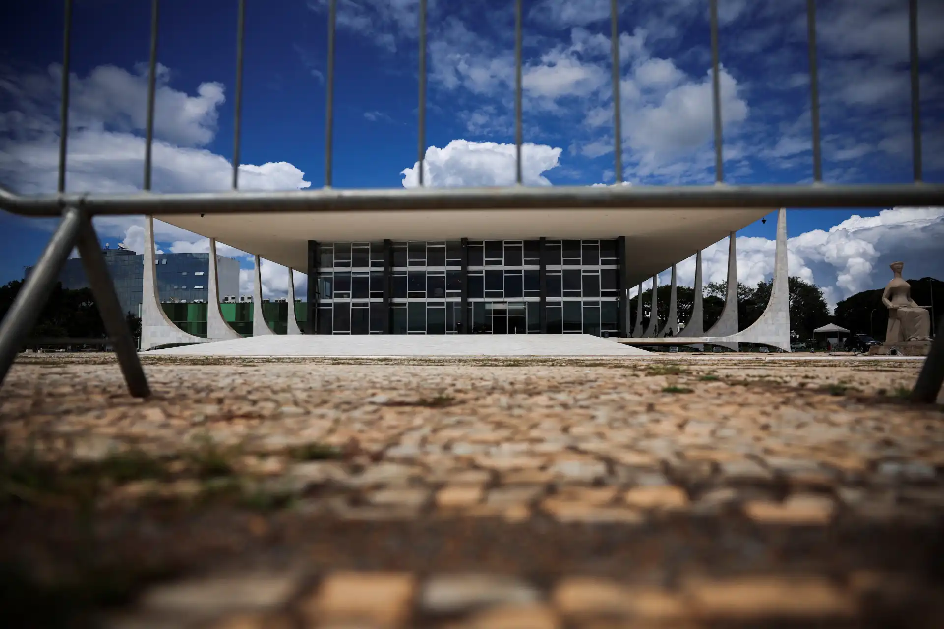 Fotografia da arquitetura moderna do Palácio da Alvorada em Brasília ao meio-dia, com céu azul e nuvens, destacando o design inovador do prédio.