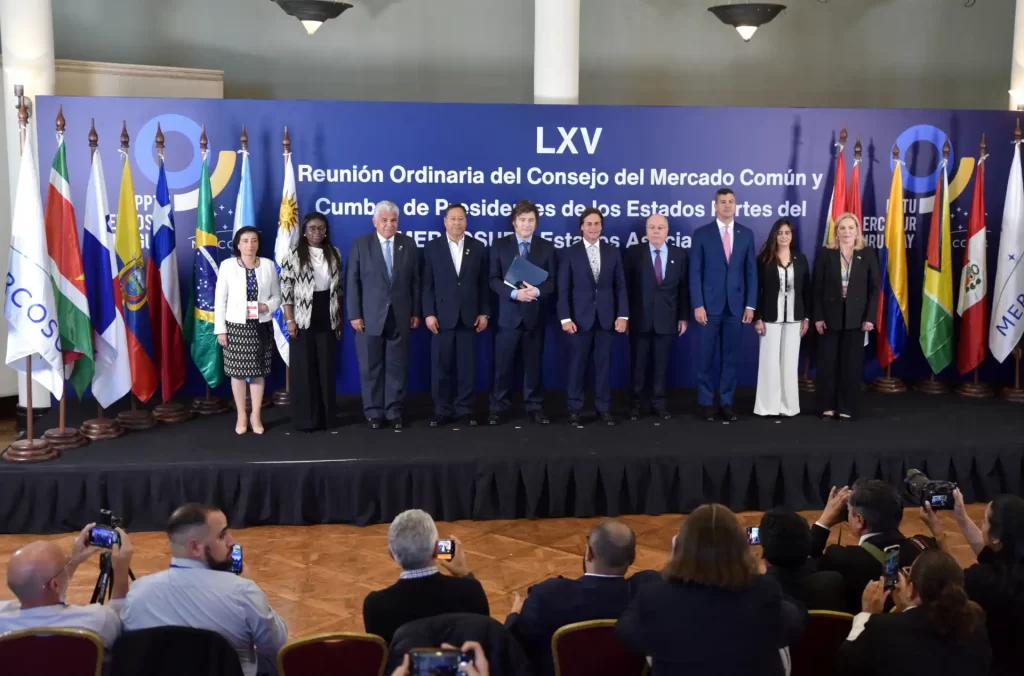 Reunião do Conselho do Mercado Comum e Cúpula de Presidentes dos Estados Unidos na América do Sul com vários líderes em uma conferência oficial, com bandeiras de diferentes países ao fundo.