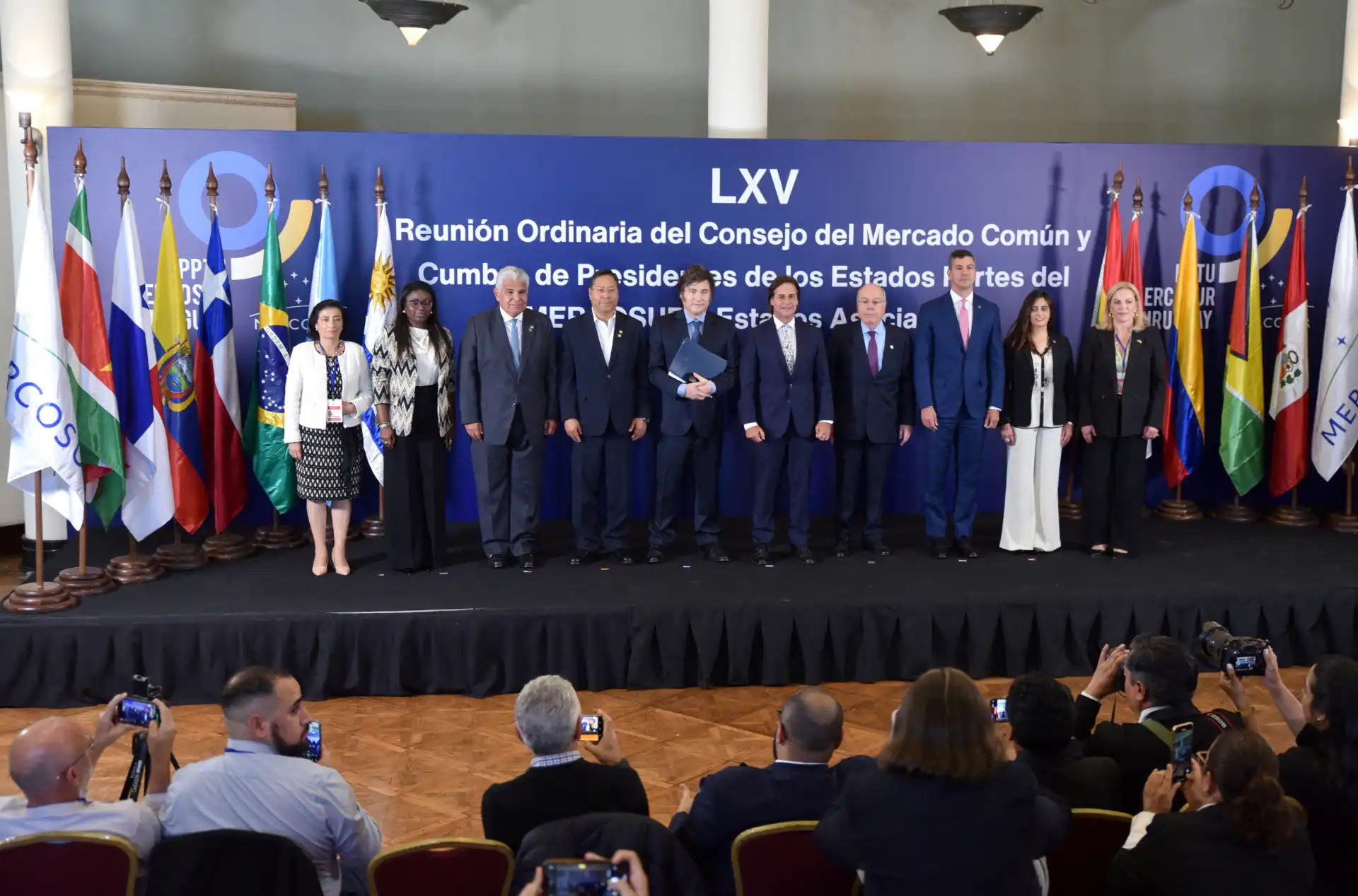Reunião do Conselho do Mercado Comum e Cúpula de Presidentes dos Estados Unidos na América do Sul com vários líderes em uma conferência oficial, com bandeiras de diferentes países ao fundo.