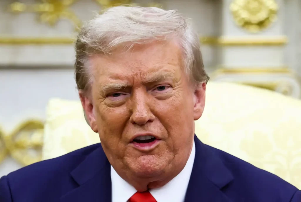 Imagem de Donald Trump, ex-presidente dos Estados Unidos, falando durante uma entrevista, com expressão facial séria e cenário de fundo elegante.
