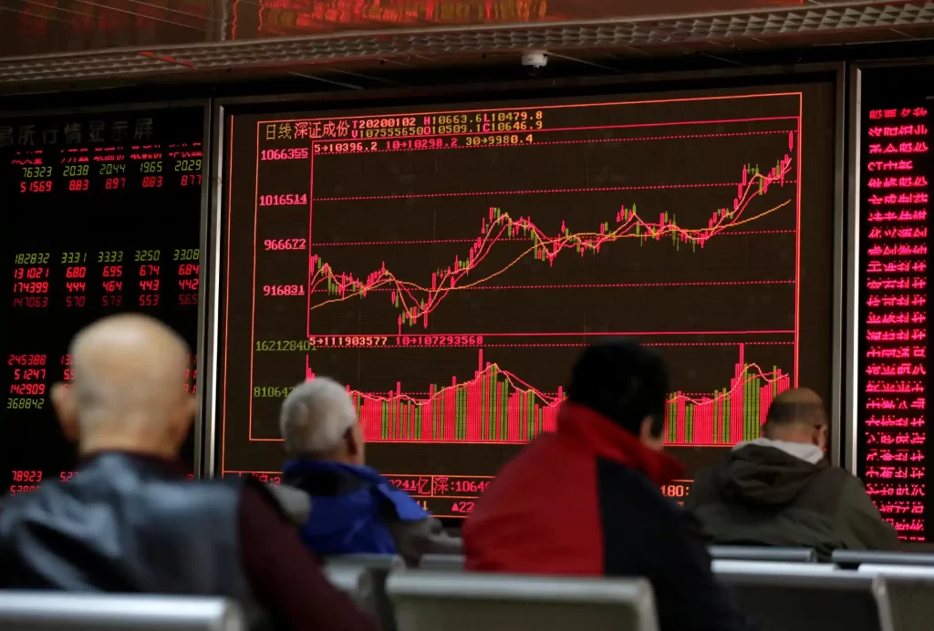 Investidores observando uma tela com gráficos de ações financeiras em uma bolsa de valores na China, com crescimento de mercado e movimentação de capitais.