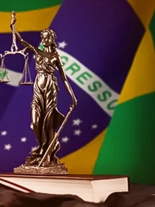 Balança de justiça, martelo da magistratura e livro, com fundo da bandeira do Brasil, simbolizando o sistema jurídico brasileiro