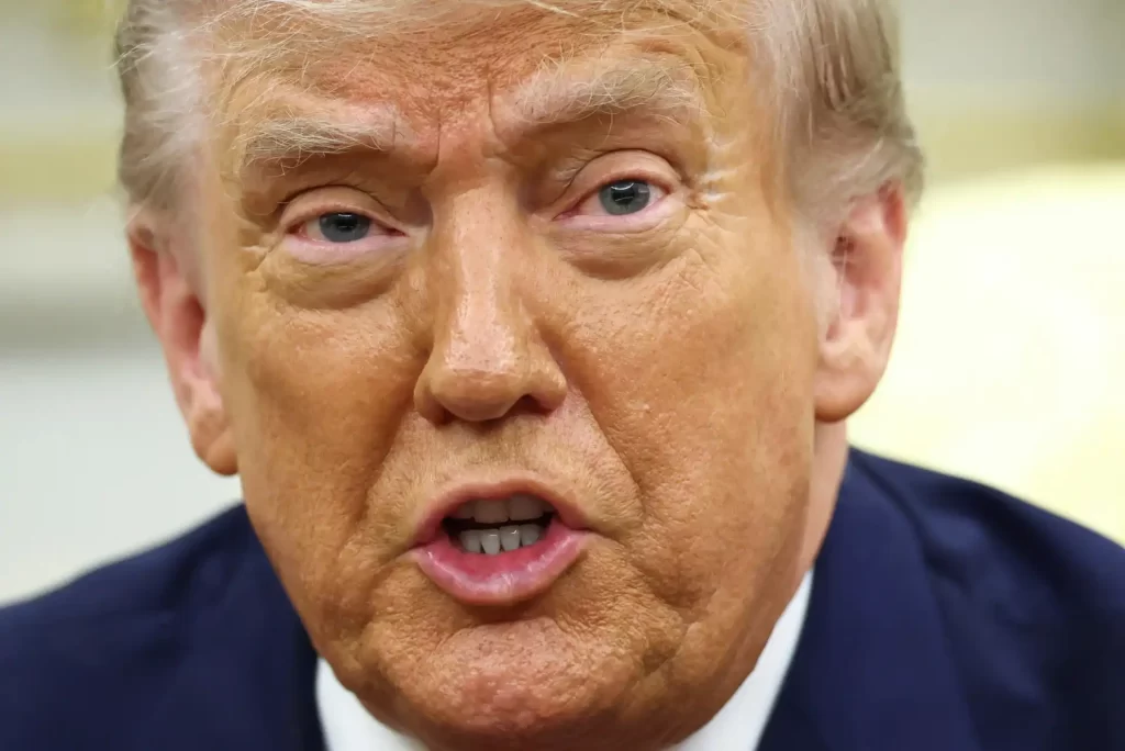 Imagem de Donald Trump com expressão facial séria e aparência marcante, destacando seus traços faciais e cabelos característicos.