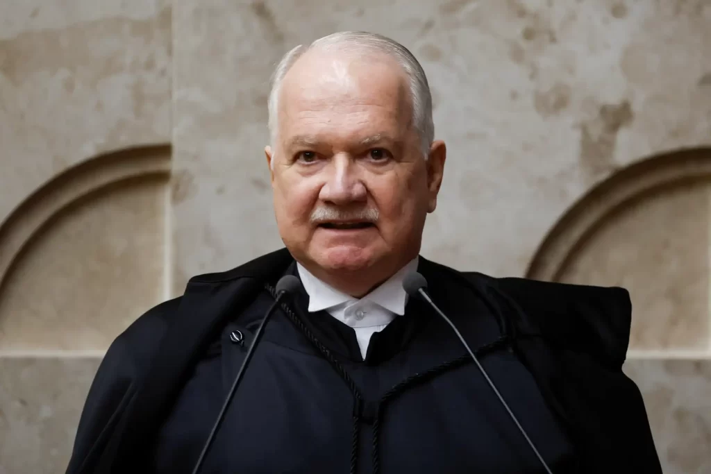 Fachin assume presidência do Supremo e prega "contenção" Imagem de um homem idoso vestido com terno e capa preta, falando em um ambiente formal e sério, possivelmente durante um evento ou sessão judicial.