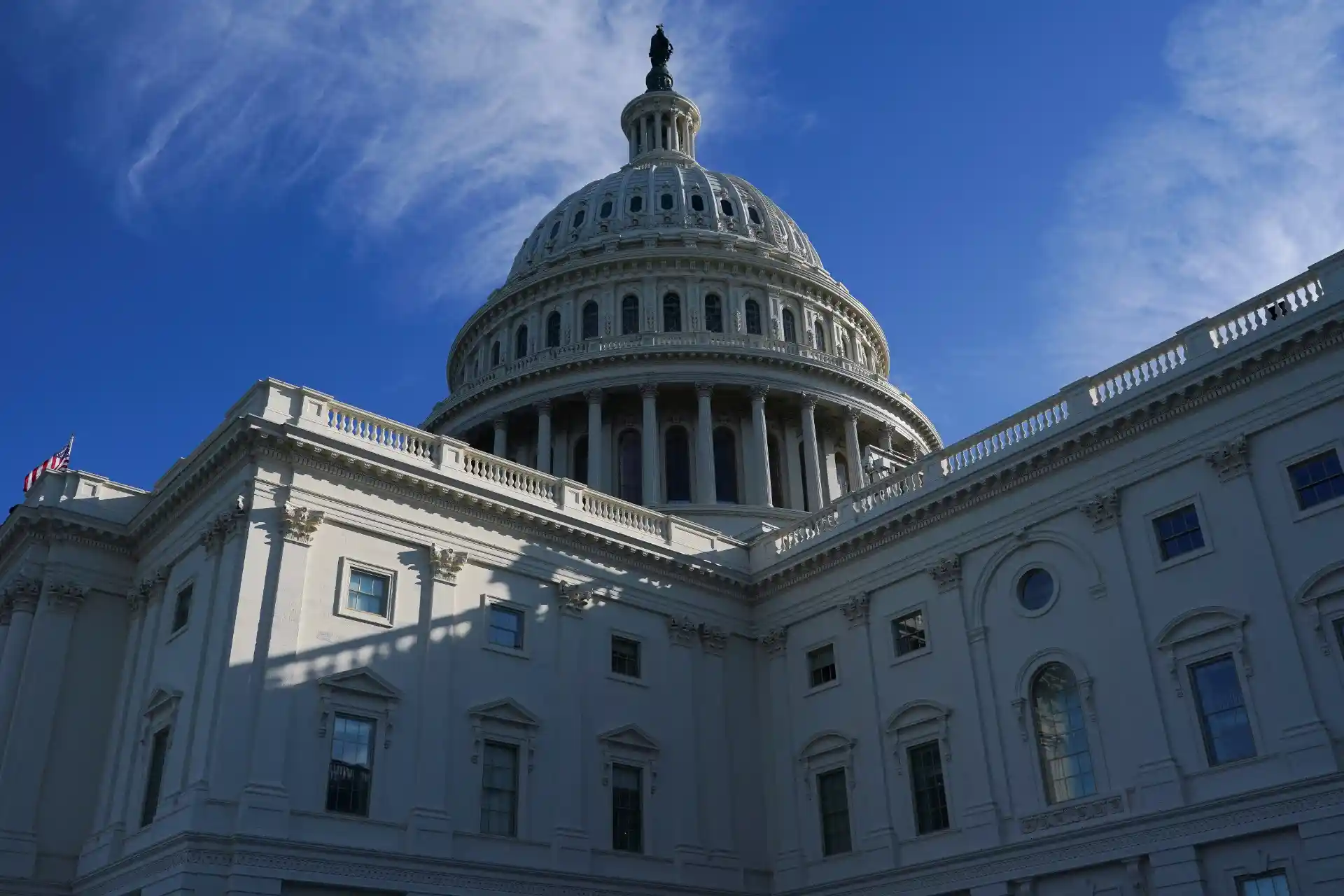 Imagem do Capitólio dos Estados Unidos, expressando sua arquitetura icônica e a cúpula imponente sob um céu azul claro.
