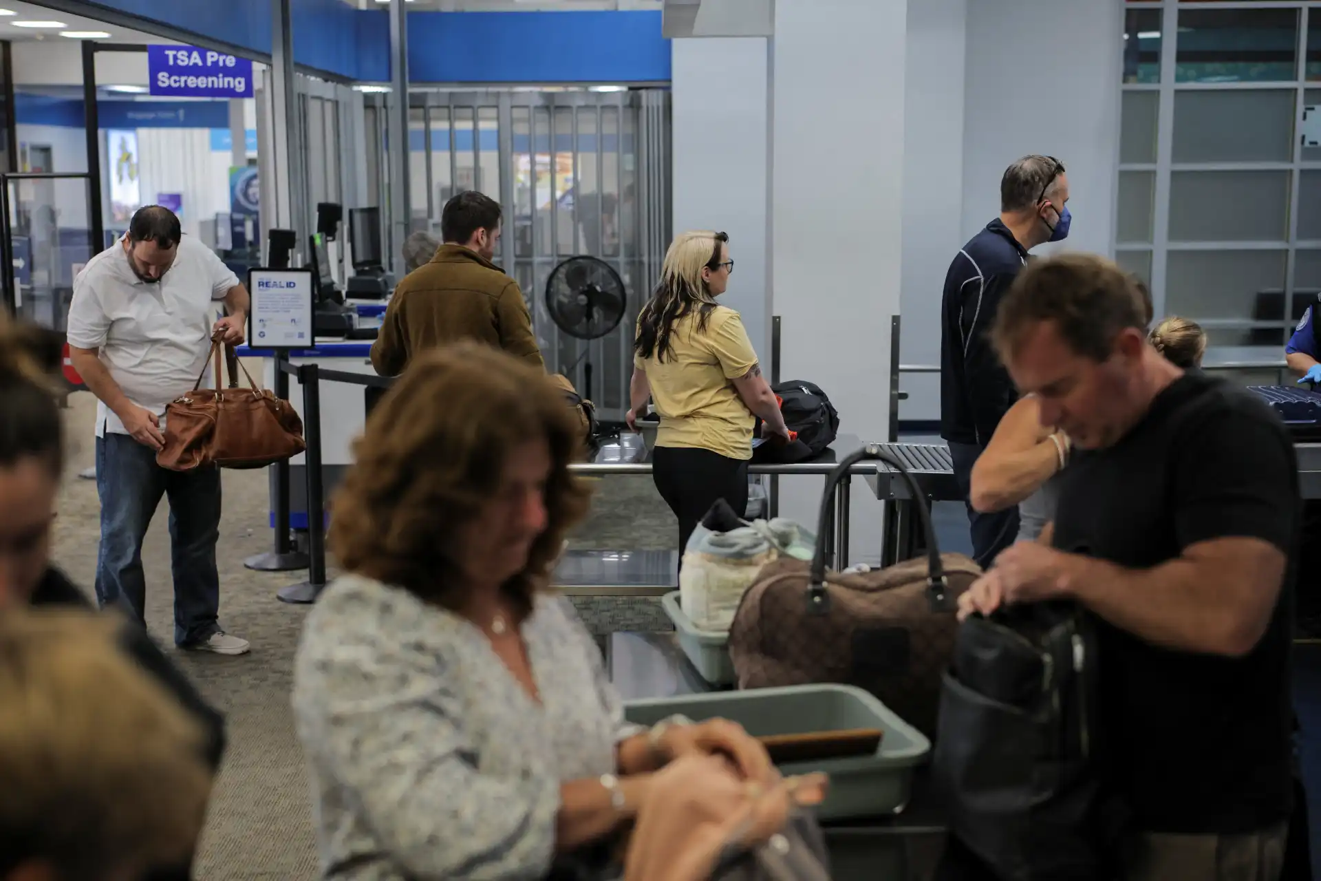 Voos internacionais e controle de segurança no aeroporto com passageiros aguardando em fila, check-in e procedimentos de segurança.