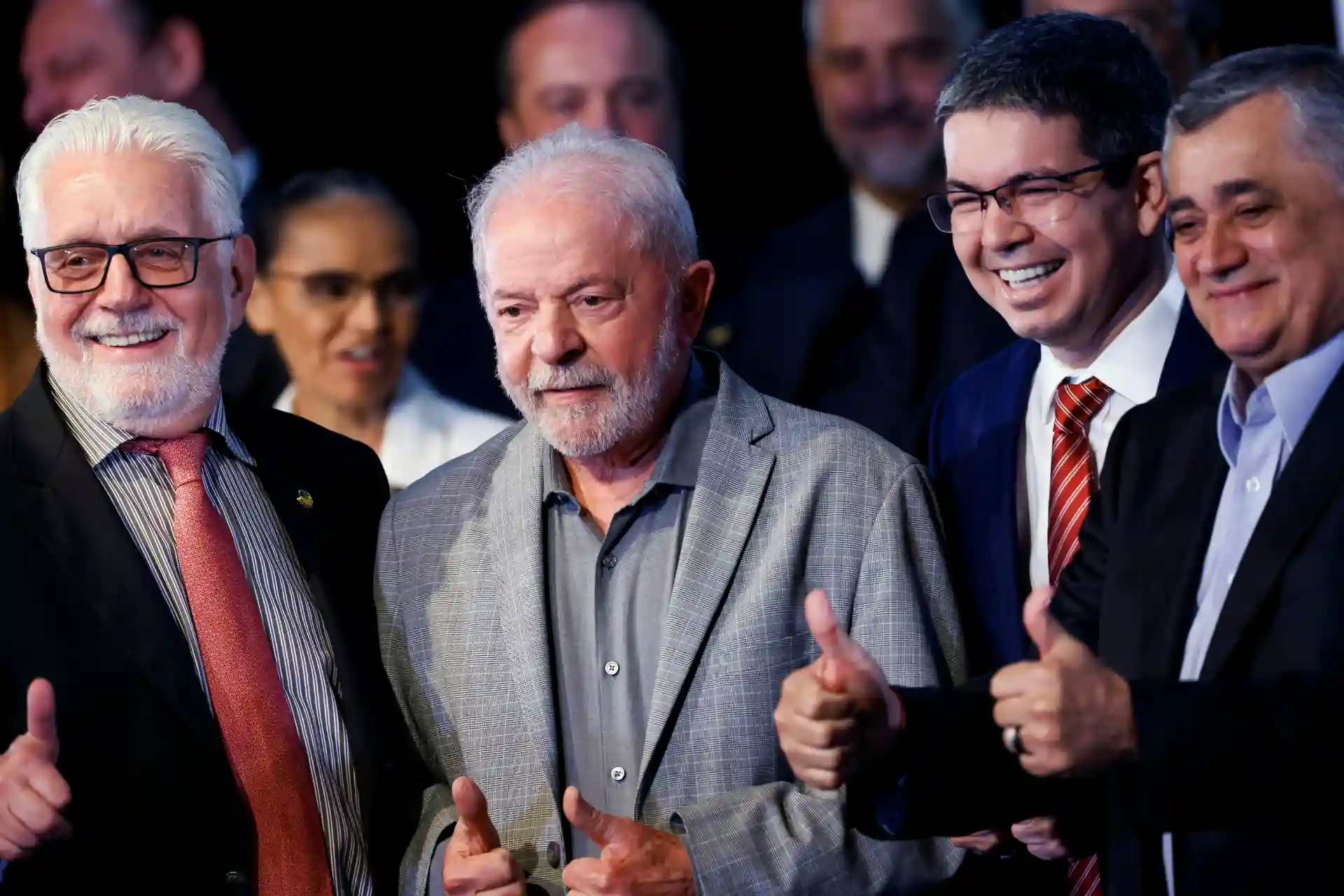 Imagem de um grupo de homens sorrindo e celebrando, com destaque para o trabalhador mais velho ao centro, em um evento social ou político, destacando solidariedade e alegria.