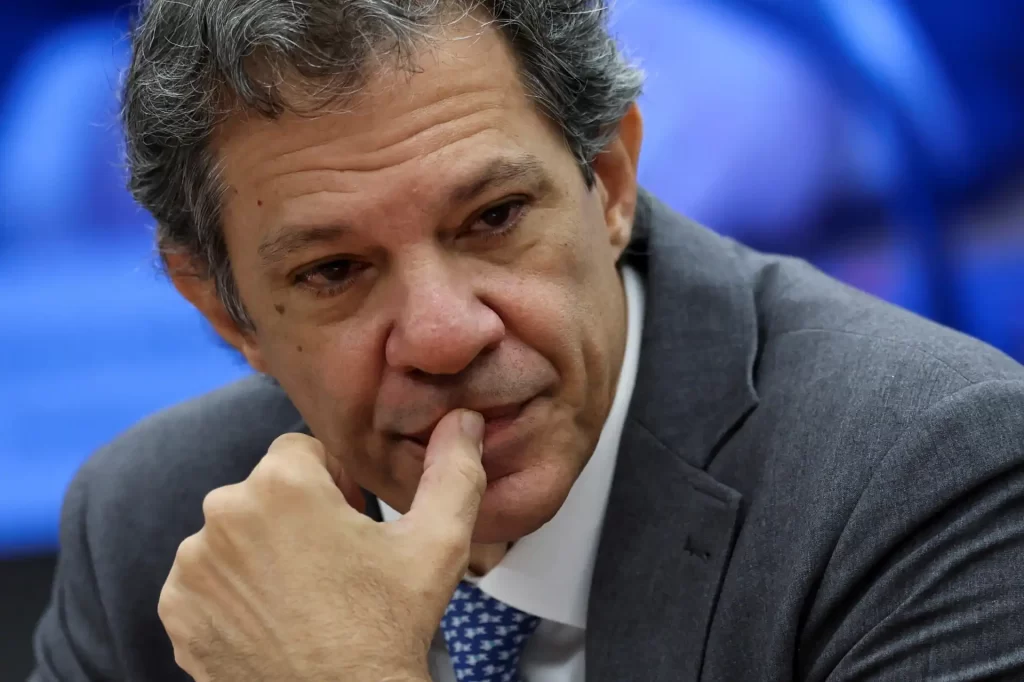 Homem pensativo, de terno, com expressão séria, em ambiente profissional, representando reflexão e análise em negócios ou eventos políticos.