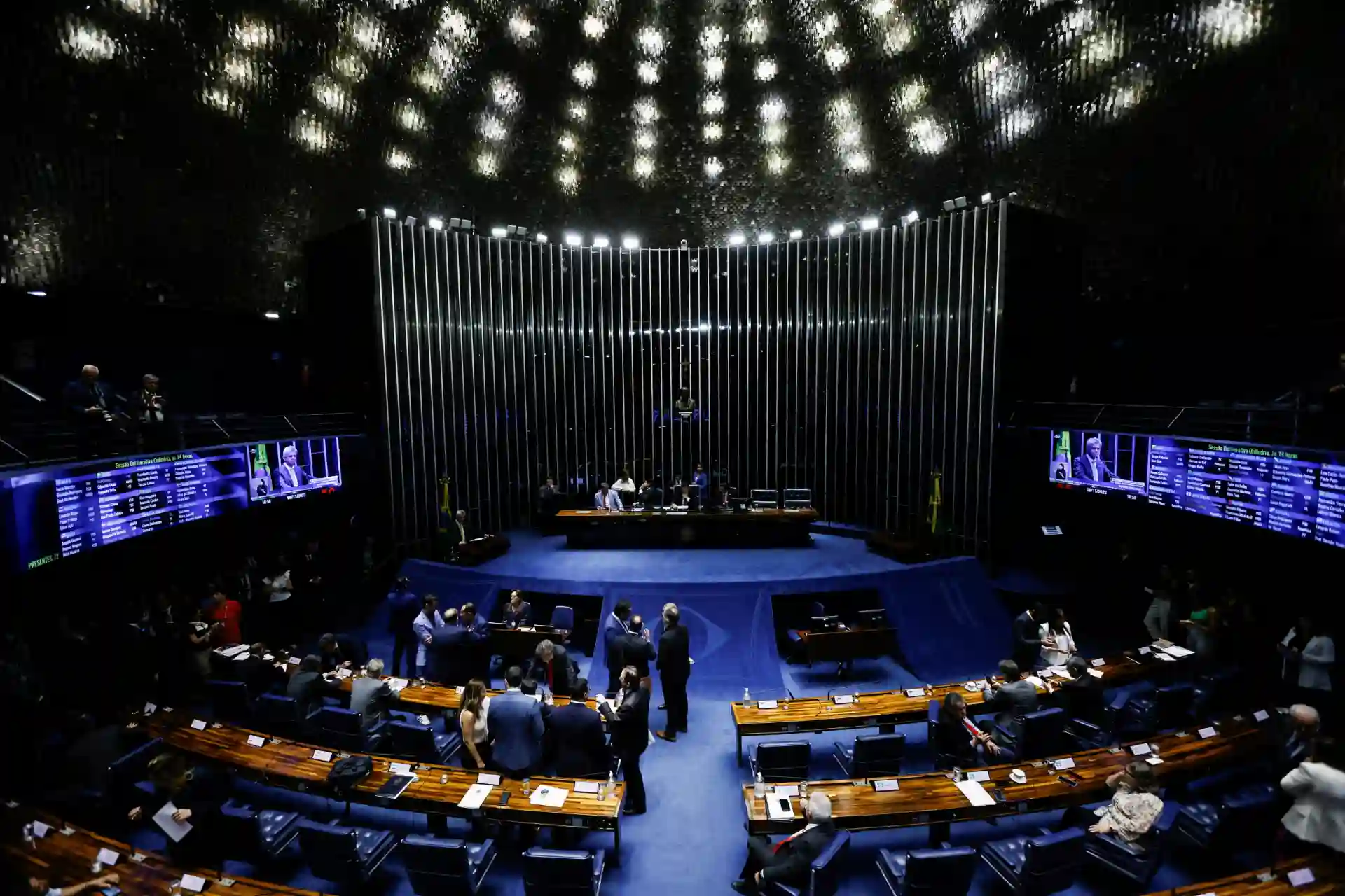 Foto da Câmara dos Deputados do Brasil, com plenário cheio de deputados e painel eletrônicos visíveis, durante sessão legislativa