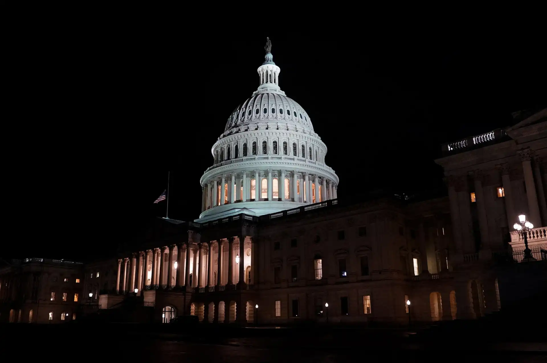Imagem do Capitólio dos Estados Unidos iluminado à noite, com destaque para sua cúpula icônica em Washington D.C. símbolo de poder e democracia americana.