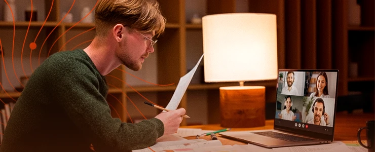 Homem participando de uma reunião virtual por computador em ambiente acolhedor com iluminação quente, ideal para trabalho remoto e videoconferências.