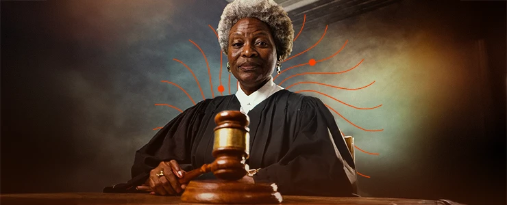 Imagem de uma juíza negra de cabelos grisalhos, vestindo toga preta, sentada em frente a um martelo de juiz, simbolizando justiça e autoridade legal. consciência negra